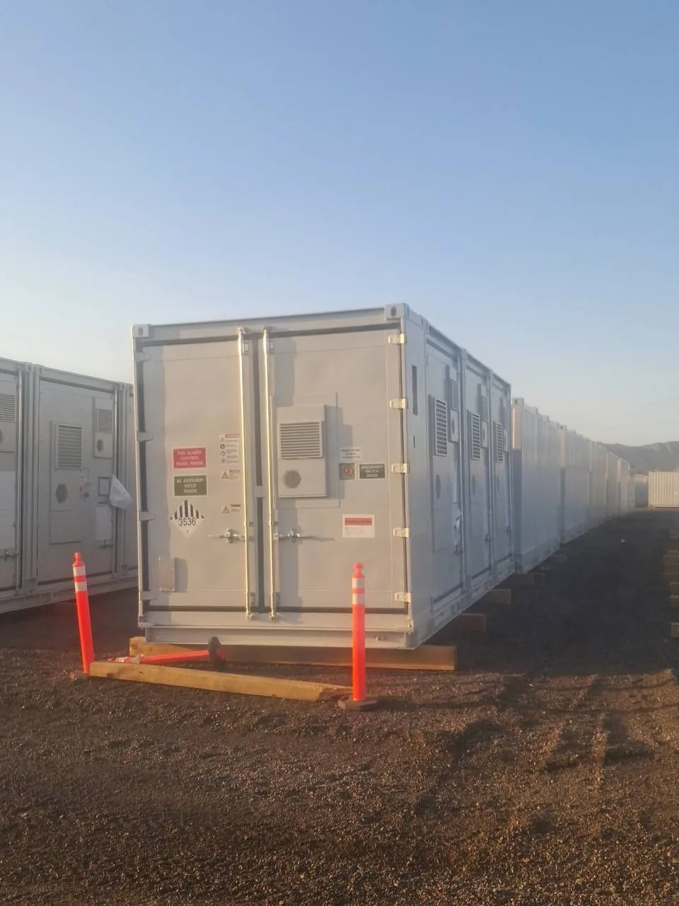 Close view of a battery energy storage container door showing the Class 9 UN3536 placard and fire-alarm control panel label
